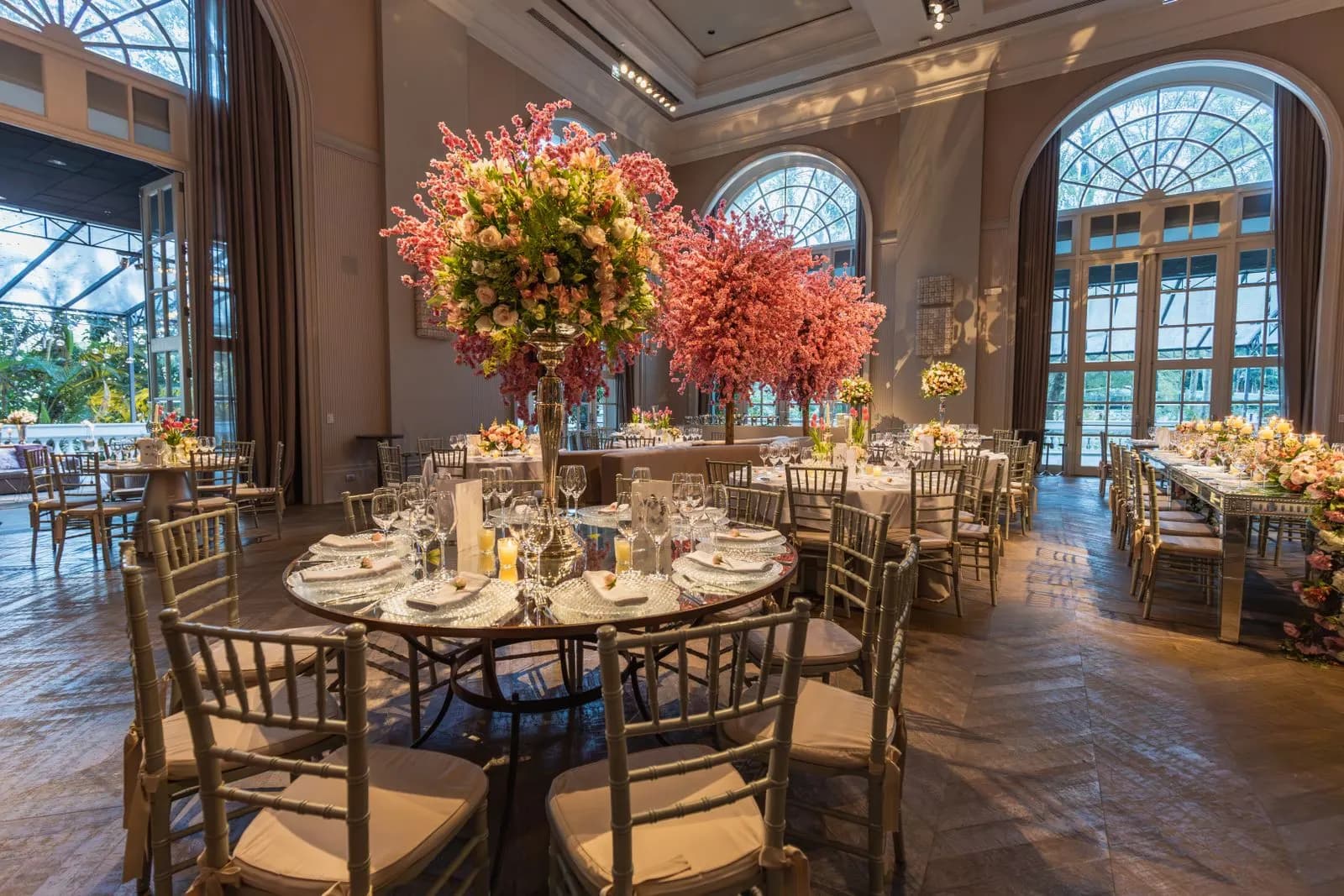 Ballroom dengan meja bundar dan rangkaian bunga