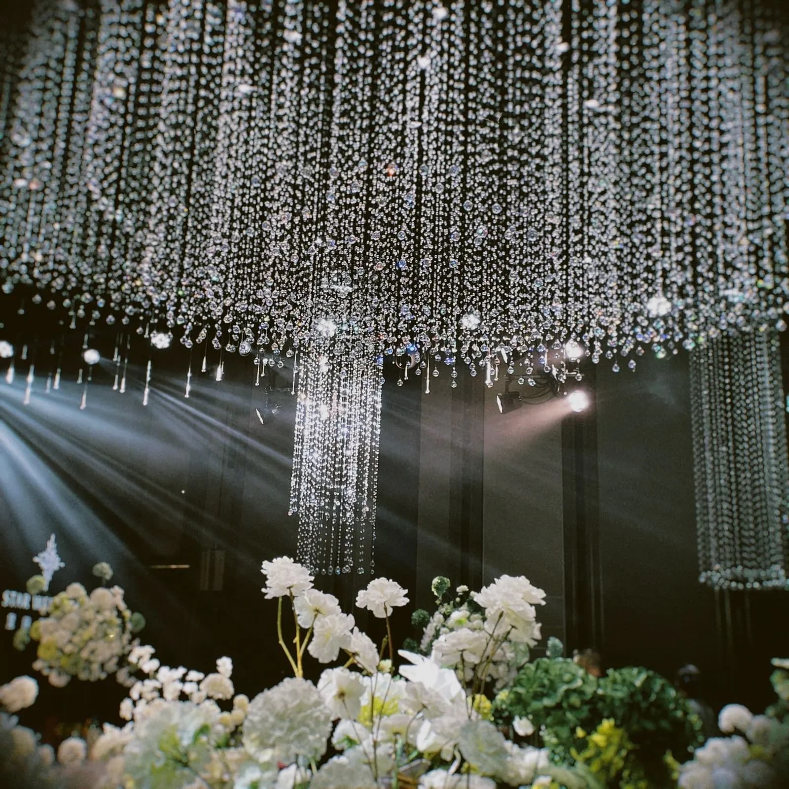 Chandelier kristal di atas rangkaian bunga putih